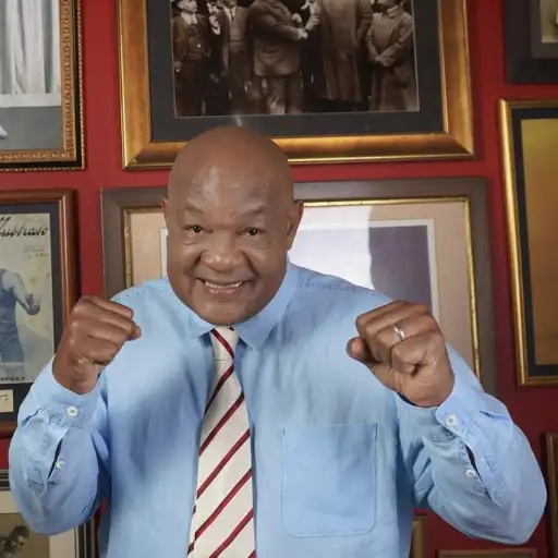 George Foreman, pictured in an office with boxing photographs behind him